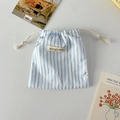 Dettaglio della borsa a coulisse a righe blu con etichetta Mayrabbit e fiocco decorativo - Bianco a Righe Blu Fiocco Blu