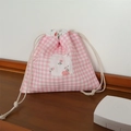 Dettaglio di un sacchetto a quadretti rosa con patch floreale su tavolo in legno - Quadri Rosa