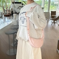 Pink crescent crossbody bag with adjustable wide strap shown in casual setting - Water Pink