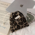 Detailed view of plush leopard print drawstring bag with minimalist brand label on it - Plush Brown Leopard