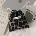 Close-up of leopard print plush drawstring storage bag with brand label on white fabric - Plush Grey Leopard