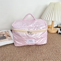 Detail of pink waterproof makeup bag featuring quilted bow pattern and dual zipper closure - Small Bow Pink