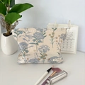 Dettaglio della borsa trucco jacquard floreale con etichetta May Rabbit su tavolo - Borsa Trucco Tarassaco Blu