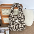 Detailopname van de pluche draagtas met luipaardprint op een geweven vloerkleed - Pluche Bruin Luipaard