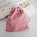 Detail of pink corduroy drawstring bag with textured fabric and white cotton rope - Nude Pink