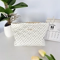 Detail of white quilted cosmetic bag with heart stitching, polka dots, and zipper closure - Polka Dot Heart