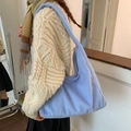 Light blue faux fur tote bag with wide shoulder strap carried by a fashion model - Light Blue