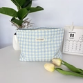 Detail of blue and yellow checkered quilted makeup bag with May Rabbit label - Checkered Heart