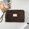 Vista dettagliata del tessuto peluche marrone e dell'etichetta sulla grande borsa portaoggetti - Marrone