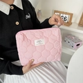 Pink quilted travel makeup bag with woven label and secure zipper closure detail - Quilted Gourd Pink