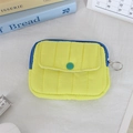 Detailed macro view of yellow quilted mini pouch with blue zipper and green button detail - Quilted Vertical Stripe Yellow