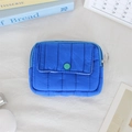 Close-up of bright blue quilted nylon mini pouch with green snap button and metal zip ring - Quilted Vertical Stripe Royal Blue