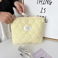 Dettaglio della borsa da trucco trapuntata gialla con cuciture a onda ed etichetta - Trapuntato Zucca Giallo