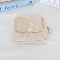 Gros plan d'une mini pochette matelassée beige avec fermeture éclair et bouton - Motif de Biscuit Abricot Gaufré