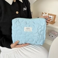 Dettaglio della pochette trapuntata azzurra con ricamo floreale e nastro di raso bianco - Poliestere Floreale Blu