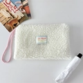 Dettaglio della borsa in pile sherpa bianco con cordino rosa e ricamo decorativo - Bianco