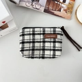 Close-up of black and white checkered canvas pouch with leather tag and zipper - Woolen Large White Plaid