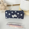 Dettaglio dell'astuccio in tela blu a fiori con cerniera e logo May Rabbit sulla scrivania - Quadrifoglio Blu Notte