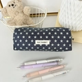 Dettaglio dell'astuccio in denim blu con stelle e etichetta in un contesto lifestyle - Stelle Blu Scuro
