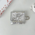 Detalle de funda plateada acolchada con acabado metálico y cierre de botón a presión - Pequeño / Plata (Perlado)
