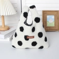 Detailed view of plush lamb wool handbag with polka dots and brown logo tag - Black Polka Dot
