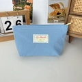 Himmelblaue Mini-Kosmetiktasche mit Webetikett und kontrastierendem grünen Reißverschluss - Blau