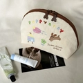 Dettaglio delle cerniere a forma di orso e ricamo a cucciolo sulla borsa in tela - Cucciolo (Beige)