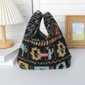 Dettaglio borsa in peluche con motivi etnici ed etichetta in pelle su piano bianco - Plaid foglia d'acero
