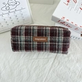 Detailweergave van het rood-groene geruite etui met een bruin leren merklabel erop - Wollen Rood Grijs Geruit
