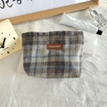 Detailed view of plaid wool cosmetic bag with brown leather logo on white linen - Woolen Blue Gray Plaid