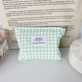 Detail of green and white checkered seersucker makeup bag with a central woven label - Green Check