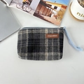 Detail of vintage plaid coin purse featuring a leather logo tag and woven zipper pull - Woolen Dark Gray Beige Plaid