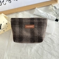 Macro-opname van geruite wollen make-uptas met leren logopatch op de zachte stof - Wollen Khaki Bruin Geruit