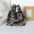 Dettaglio della borsa in peluche con motivo paisley bianco e nero e logo in pelle - Totem nero etnico