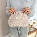 Gros plan détaillé d'une trousse de maquillage en toile aux motifs floraux roses - Fleur Rose