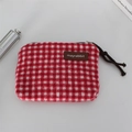 Close-up of red plaid knit coin purse featuring a leather logo tag and zipper puller - Woolen Square Red Plaid