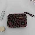 Detail shot of leopard print plush coin purse with lipstick and dark grey background - Woolen Pink Leopard Print