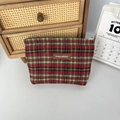 Detail der rot-grünen Karo-Kosmetiktasche mit Leder-Markenaufnäher auf dem Stoff - Wolle Rot Karo