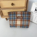 Detailaufnahme der Woll-Kosmetiktasche mit Karomuster, Lederlogo und Metallreißverschluss - Wolle Blau Karo