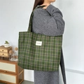 Detail of green plaid wool tote bag with white woven label showing texture and capacity - Woolen Green Plaid