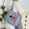 Detailansicht der lila Nylon-Tasche mit Blumenmuster und May Rabbit Logo-Schriftzug - Zweifarbige Blume Doppelschicht Schulter / Lila