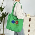 Detailansicht der grünen Tragetasche mit Tulpenstickerei und May Rabbit Schriftzug - Zweifarbige Blume Doppelschicht Schulter / Grün