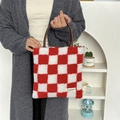 Detail of red and white checkered plush tote bag with leather handles and brand label - Plush Checkerboard Red Grid