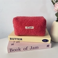 Détail de la trousse en polaire peluche rose corail avec texture douce et étiquette - Rouge Pastèque