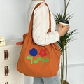 Detailansicht der orangefarbenen Canvas-Tasche mit Blumenstickerei und Kordelzugverschluss - Zweifarbige Blume Doppelschicht Schulter / Orange