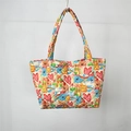 Detailed close-up of quilted floral tote bag with cute cartoon prints and metal snap button - Graffiti