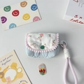 Detailed view of mini floral quilted bag with pink pompom trim and woven hand strap - Pink Floral + Quilted Gourd Blue