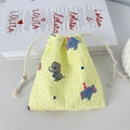 Gros plan d'un sac à cordon jaune avec texture gaufrée et motif d'éléphant de dessin animé - Éléphant Mignon