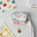 Close-up of small pink floral fabric storage pouch with blue pom-pom lace and carrying rope - Pink Floral + Quilted Gourd Pink