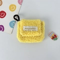Detailed view of yellow plush earphone case featuring fluffy texture and brand woven label - Small / Yellow